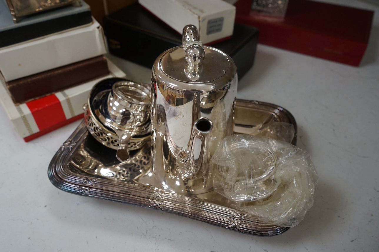 A George V silver cigarette box and assorted plated ware to include a cased cruet, a modern silver wine coaster and an embossed Dutch style tea caddy, largest 23cm wide. Condition - varies